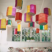 Colourful Chinese lanterns hanging from ceiling of white room