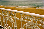 Dekoratives Eisengeländer am menschenleeren Strand von La Concha in San Sebastian