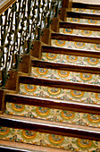 Decorative tile steps on an ornate ironwork staircase inside the National Museum of Ceramics in Valencia