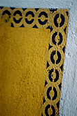 Yellow and black stenciling on a light blue wall Seville