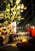 Flowers displayed beside fruit and wine glasses at a party