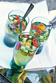 Clear tomato water with diced gazpacho vegetables in small glasses