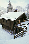 Typical wooden alpine chalet in snowy landscape