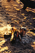 A billy can on a log fire at the Macateer Safari Camp in the Okavango Delta in Botswana