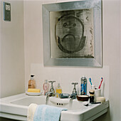 Trauriges Gesicht auf beschlagenem Spiegel über einem Waschbecken
