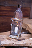 Close up of lighted candle in old tin storm lantern