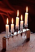Brennende Kerzen in einem Kerzenhalter aus Glas und Metall