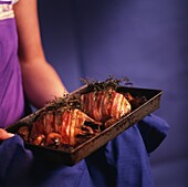 Woman holding tray with roasted pheasant