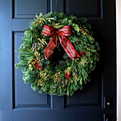 Blue panel door with festive evergreen wreath