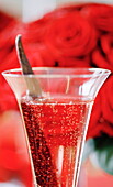 Champagne glass and red roses at Christmas in UK home
