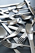 Cutlery scattered on a grey table top