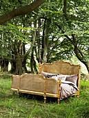 gilt double bed in woodland setting