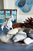 Paper horse and pebbles with pine cones in London home