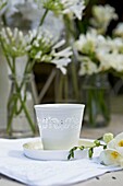 White candle holder and cut flowers on garden table   London   UK
