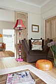 Multicoloured standard lamp with brown vintage chair in reception room of London home   UK
