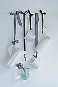 White milk jugs and single stem flower hanging with black and striped ribbon
