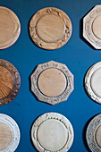 Carved decorative place mats on blue wall in Greenwich home,  London,  England,  UK