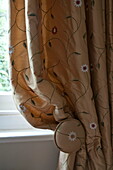 Embroidered gold curtains in contemporary Haywards Heath home,  West Sussex,  England,  UK
