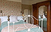Lace pillow on double bed with antique wooden wardrobe in bedroom of  Ashford home,  Kent,  England,  UK