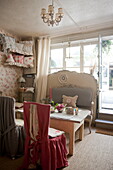 Slip covered chairs with wooden table at window of tea salon in Dordogne,  France