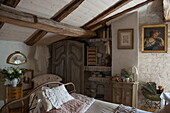 Antique metal bed in attic bedroom of farmhouse interior,  Dordogne,  France