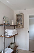 Folded towels on scaffold shelves in bathroom of Kingston home,  East Sussex,  England,  UK