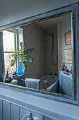 Bathroom reflected in painted blue mirror Tiverton farmhouse  Devon  UK
