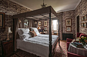 Four poster bed in wallpapered bedroom  Dordogne country house  France