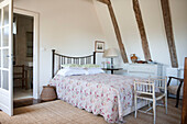 Floral quilt on double bed in timber-framed room of Dordogne farmhouse  Perigueux  France