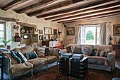 Cushions on sofas with brass-edges travelling chest in beamed barn conversion in Lotte et Garonne  France