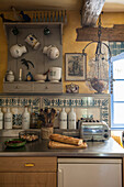 Wall mounted kitchen storage with tiled splashback at window in Lotte et Garonne farmhouse  France