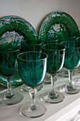 Green wineglasses and plates on shelf in Dorset home  Kent  UK