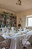 Bookcase and dining table with place settings in Dordogne cottage  Perigueux  France
