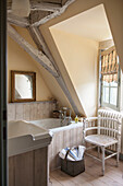 Gilt framed mirror on shelf in yellow timber framed bathroom of Dordogne cottage  Perigueux  France