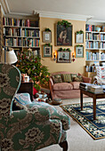 Gepolsterter Sessel und Weihnachtsbaum im Londoner Wohnzimmer England UK