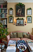 Gerahmtes Kunstwerk über dem Zweisitzer-Sofa mit Pralinen und Büchern auf dem Couchtisch in einem Londoner Haus England UK