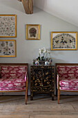 Paar gepolsterte Stühle mit lackiertem Schrank in East Barsham cottage Norfolk England UK