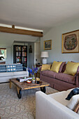 Gelbe Kissen auf Sofa mit Couchtisch aus Holz in East Barsham cottage Norfolk England UK