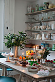 Geschirr und Gläser auf offenem Regal mit Kuchen und Obst in London home England UK
