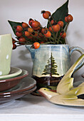 Rosehip berries in ceramic jug with bird in London home  England  UK