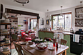 Holztisch und Stühle in der grünen Küche von Kilndown cottage Kent England UK