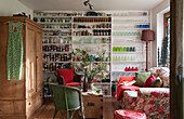 Pantry shelving and wooden cupboard with floral sofa in Kilndown cottage  Kent  England  UK