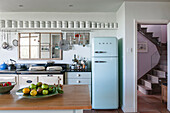 Light blue upright fridge in kitchen with storage jars  Norfolk coastguards cottage  England  UK