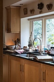 Backen neben der Spüle am Küchenfenster in einem Kutschenhaus in East Sussex, England, Vereinigtes Königreich