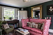 PInk divan and corner cabinet with gilt framed mirror in 18th century Surrey home  England  UK