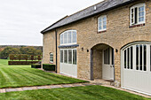 Cut lawn and view to woodland landscape from Oxfordshire barn conversion  England  UK