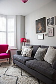 Graues Sofa und Kissen mit Kunstwerken in Reihenhaus in Whitstable Kent England UK