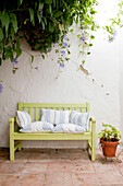 bench with cushions and flowering plants in walled Castro Marim courtyard Portugal