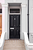 Schwarze Haustür und Stufen an der Außenseite eines Reihenhauses in Brighton, East Sussex England UK