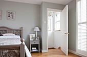 Offene Tür mit bemaltem Bett in einem Haus in Brighton, East Sussex, England, UK